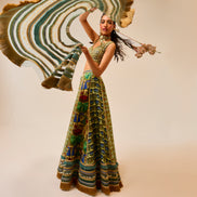 Woman in a colorful dress with a large decorative fan against a plain background