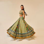 Woman wearing a traditional outfit with a patterned skirt and top on a beige background
