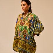 Woman wearing a colorful patterned outfit against a beige background