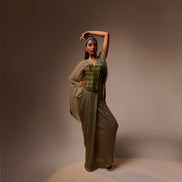 Woman in a long, textured dress with a patterned top against a brown background