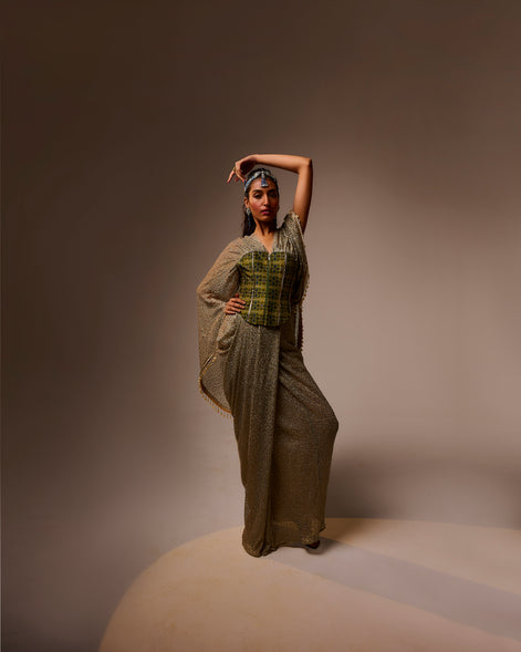 Woman in a long, textured dress with a patterned top against a brown background