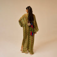 Woman wearing a green patterned dress with long hair on a beige background