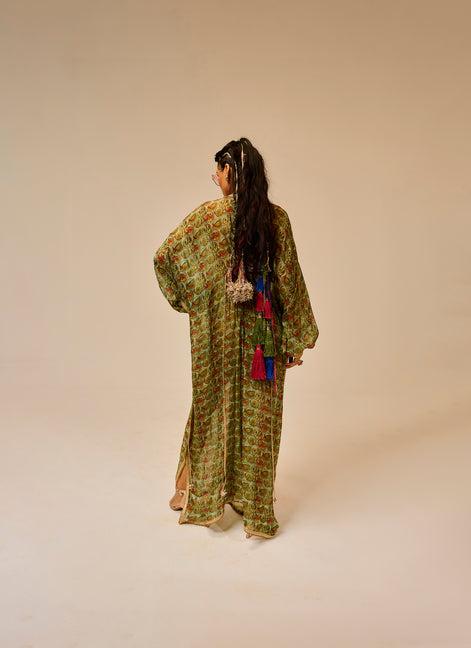 Woman wearing a green patterned dress with long hair on a beige background