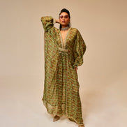 Woman wearing a long, patterned dress against a beige background