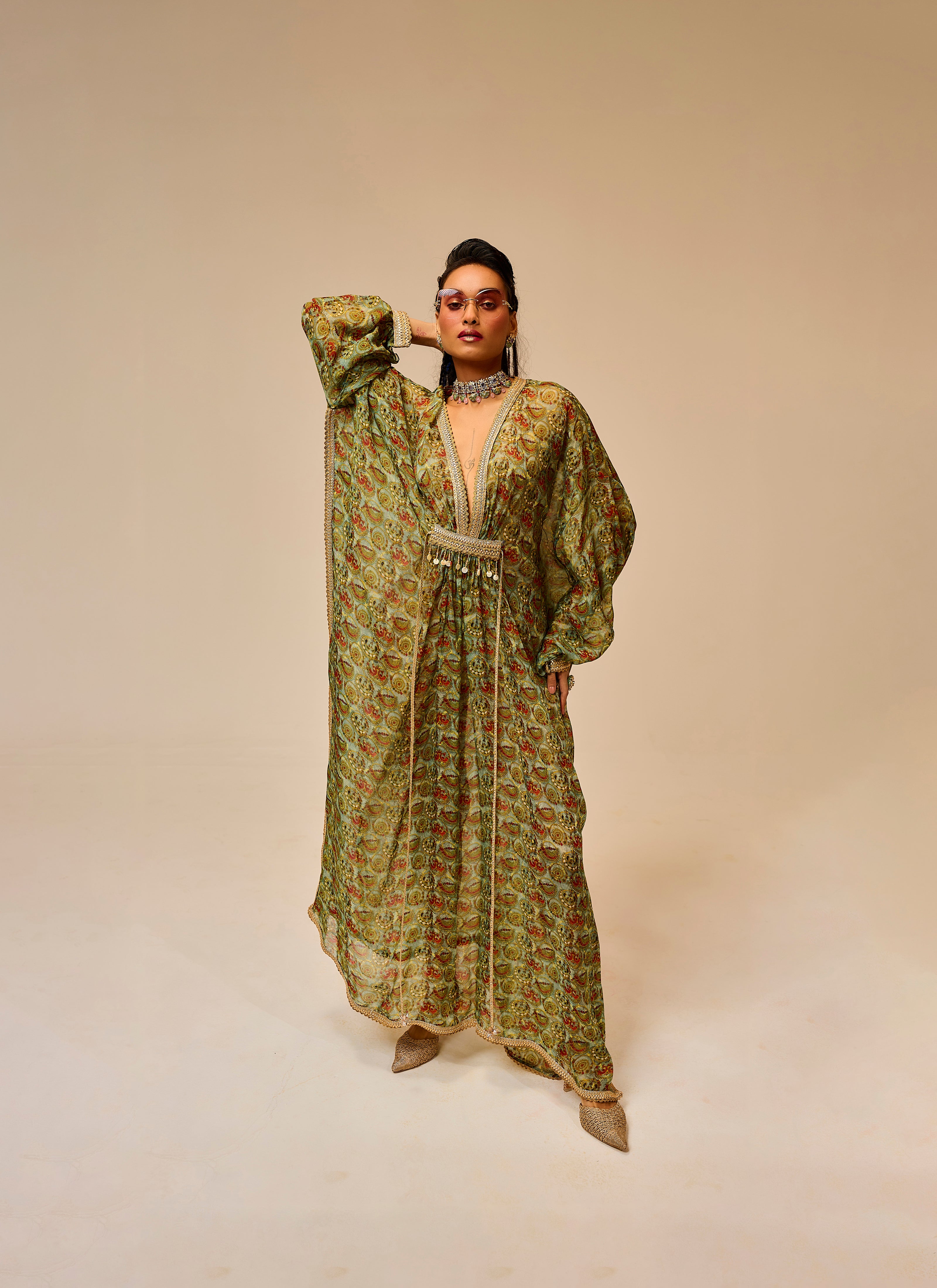 Woman wearing a long, patterned dress against a beige background
