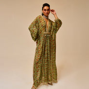 Woman wearing a green patterned dress on a beige background