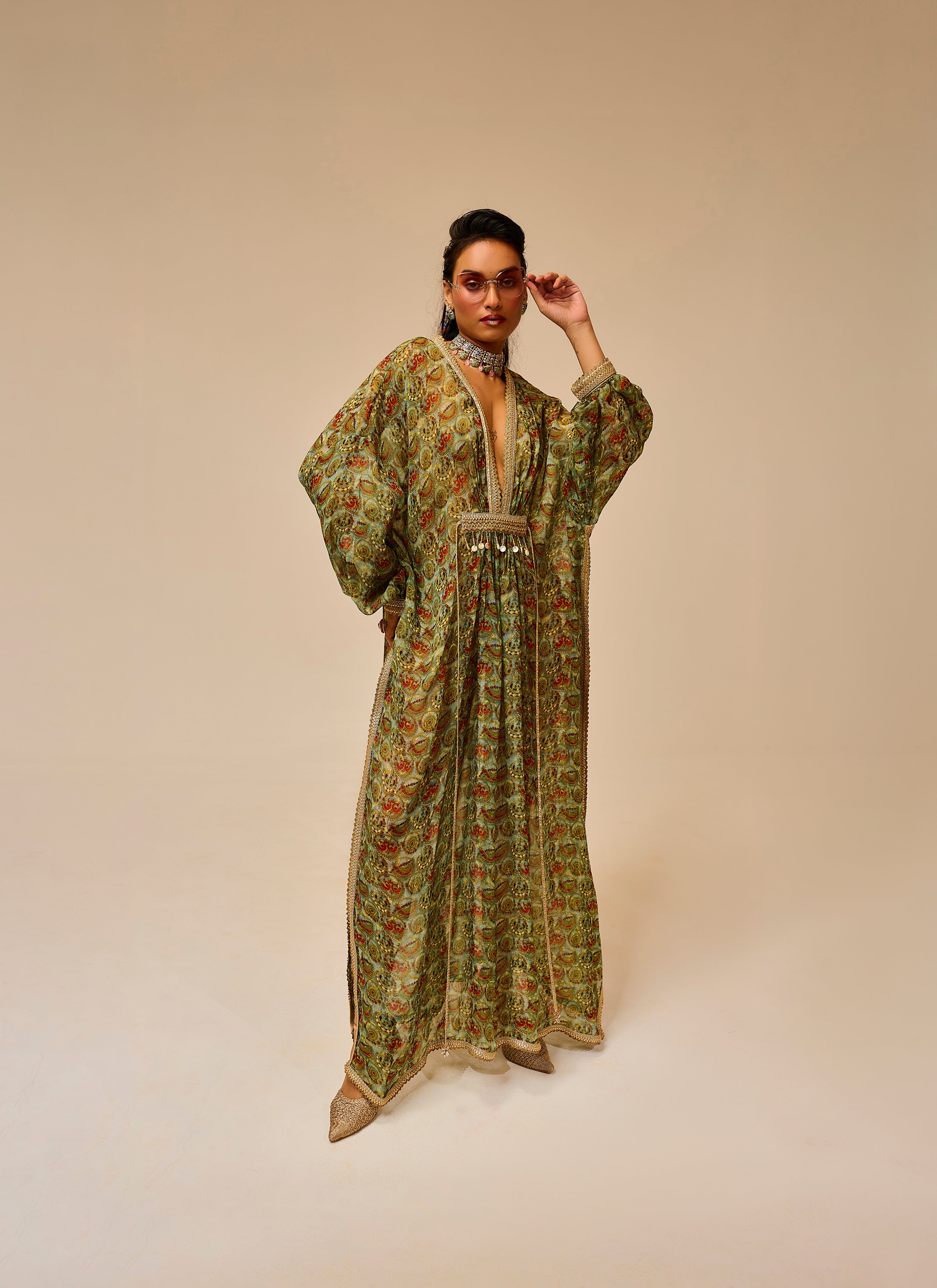 Woman wearing a green patterned dress on a beige background