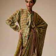 Woman wearing a traditional outfit with a floral pattern on a beige background