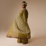 Woman wearing a traditional outfit with a patterned shawl on a beige background