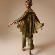 Woman wearing a patterned outfit on a beige background