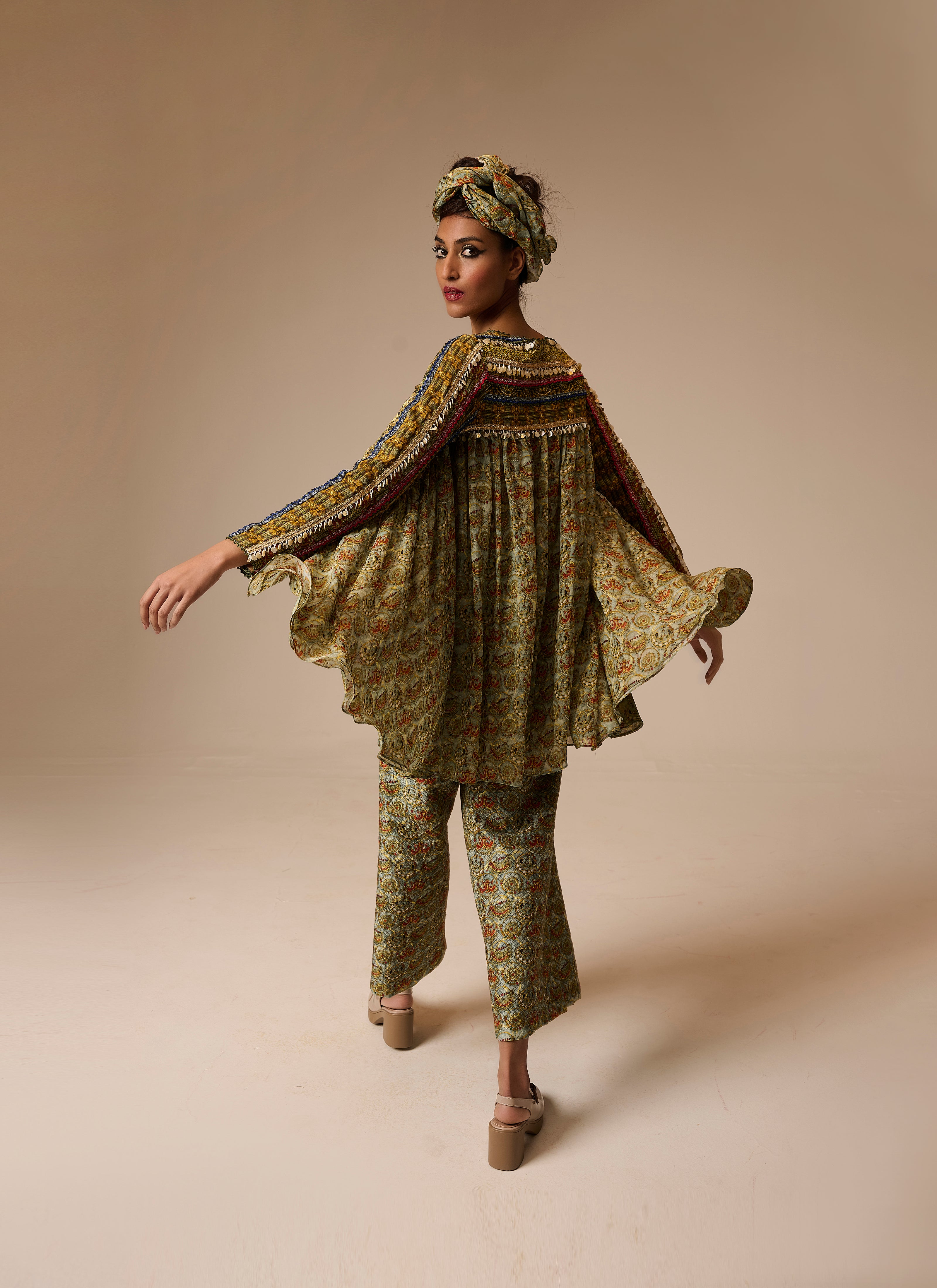 Woman wearing a patterned outfit on a beige background