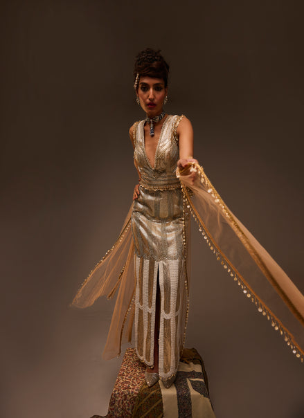 Woman in a vintage-style dress with flowing fabric against a dark background