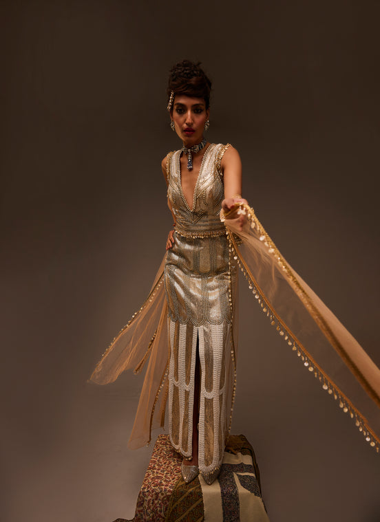 Woman in a vintage-style dress with flowing fabric against a dark background