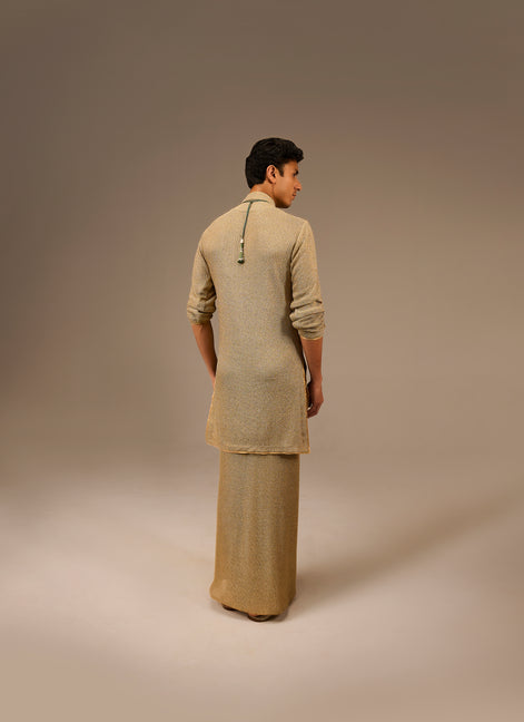 Person wearing a beige traditional outfit on a plain background