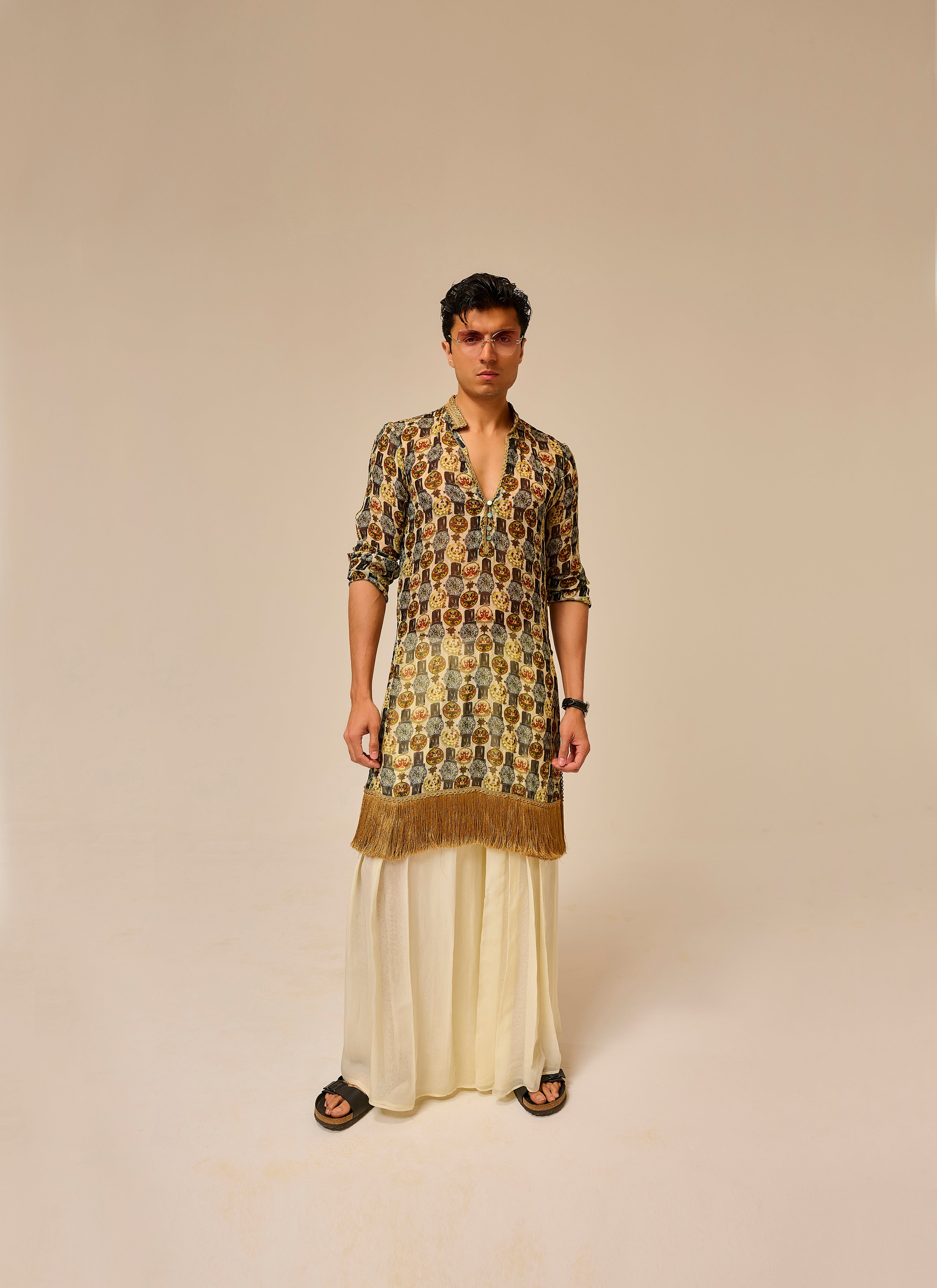 Man wearing a patterned kurta with a plain background