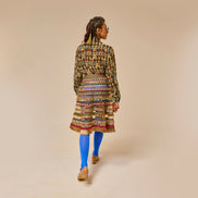 Woman wearing a patterned dress and blue socks on a beige background
